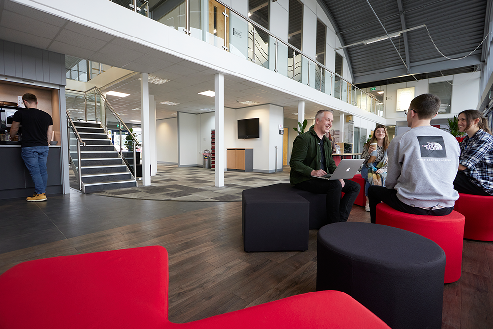 A group of people inside Sheffield Business centre enjoying the communal area.
